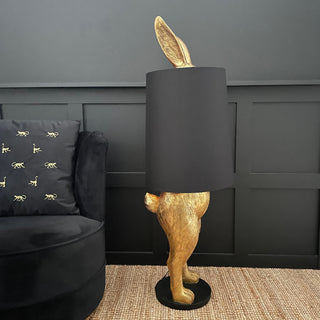 Gold bunny rabbit table and floor lamp which is hiding behind a black lampshade