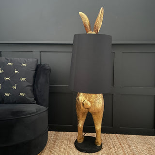 Gold bunny rabbit table and floor lamp which is hiding behind a black lampshade